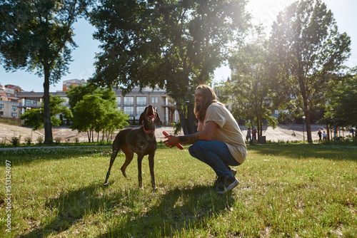 Man hold rubber ring near his Kurzhaar dog in park