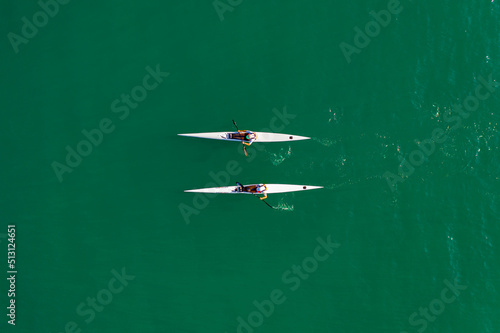  Aerial view of two white kayaks, rowing in the sea with turquoise water