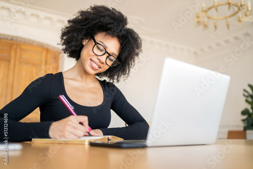 Designer female student studying online by school chat on the website, uses a laptop computer