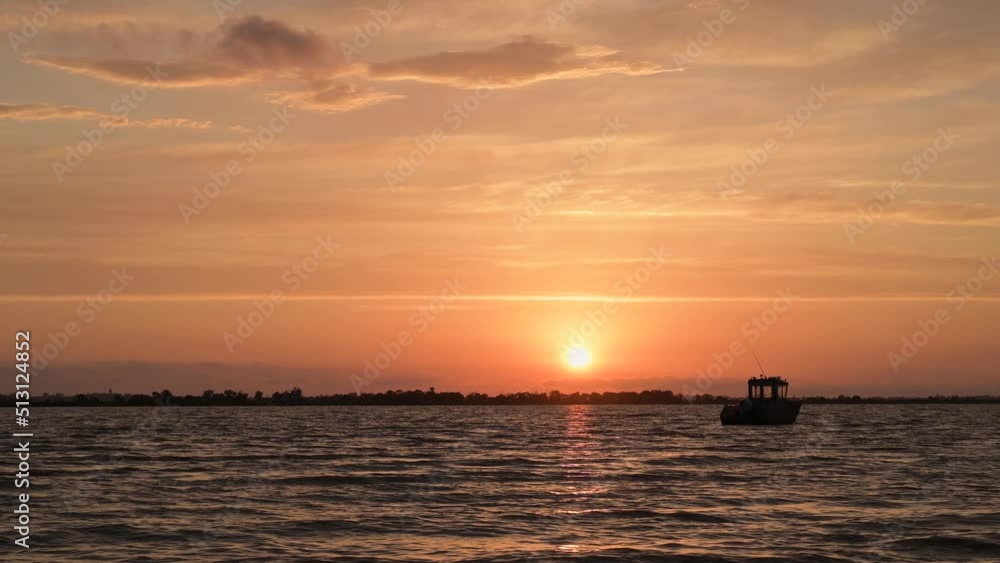 Fishing boat in the sunset on calm waters at anchor Fishing boat in the sunset on calm waters at anchor