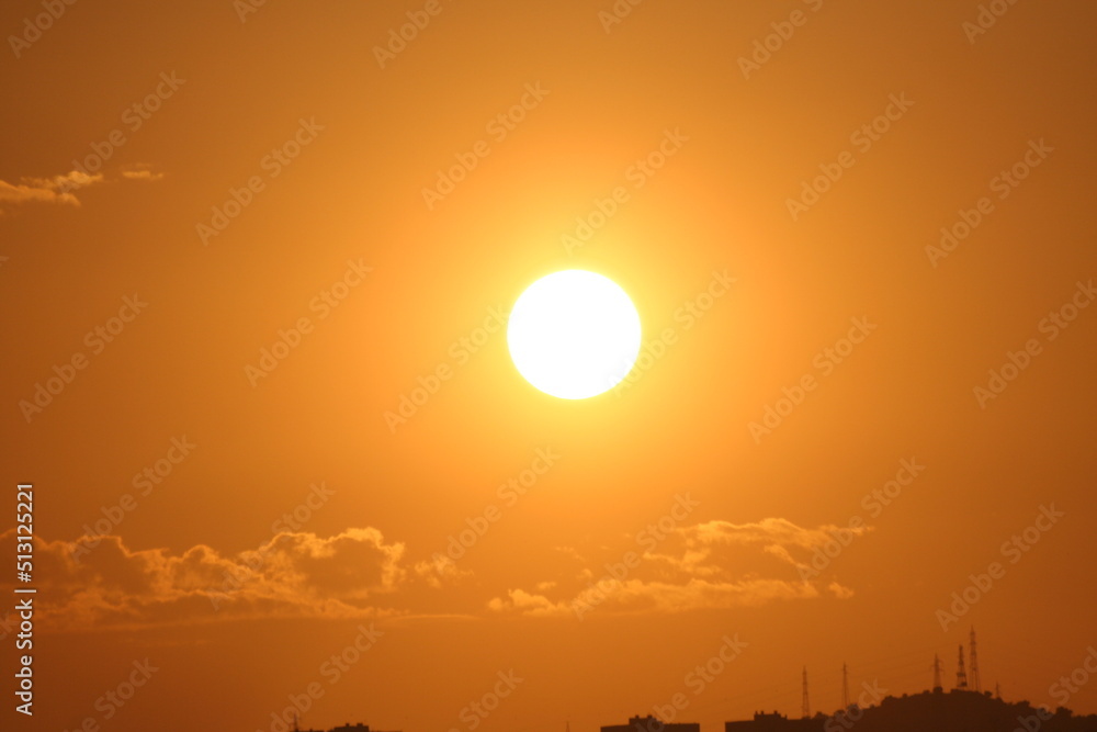 Palla arancione infuocata in cielo, sole al tramonto