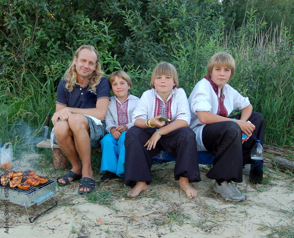 family in ukrainian embroidery camping in the woods