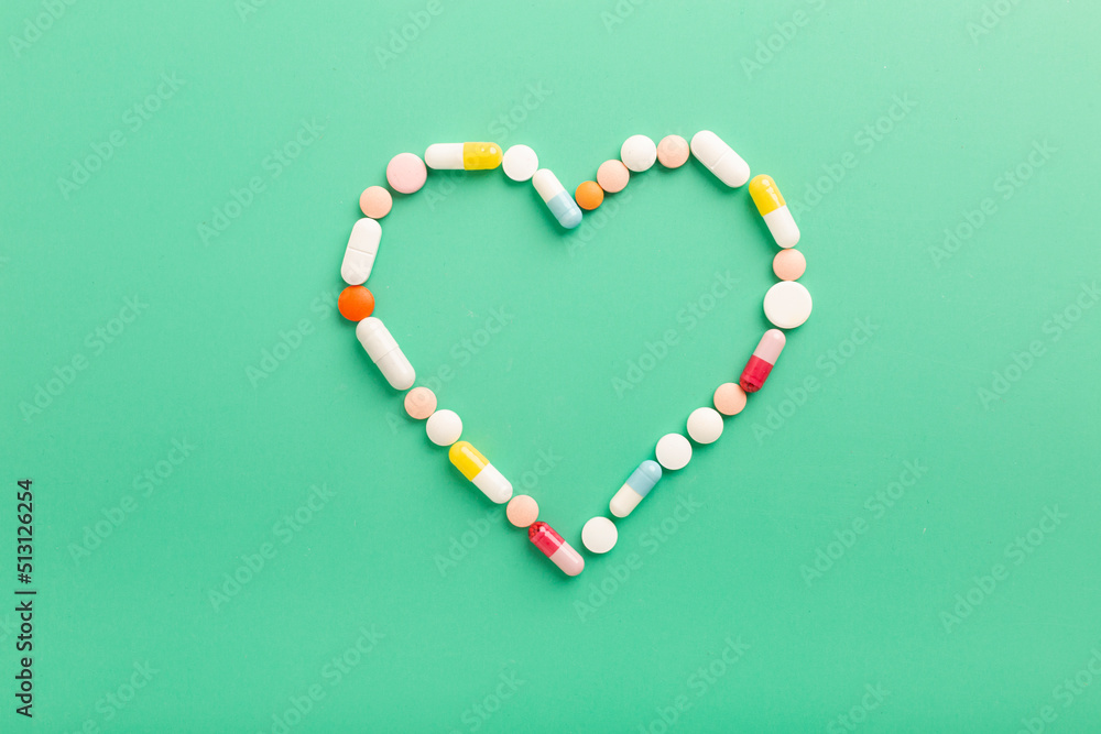 Obraz premium Various pharmaceutical tablets and capsules for the treatment of heart disease. Heart shape and a bottle of pills. Copy space for text