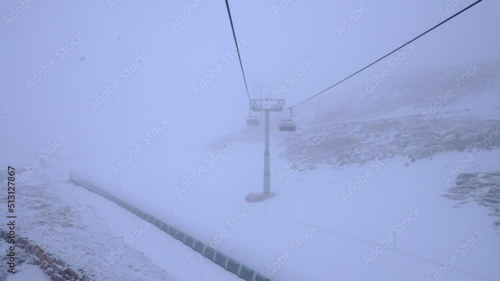 Empty chairlift in a ski resort on a foggy cloudy day. Winter season in Alpine mountains. Empty chairlift in a ski resort on a foggy cloudy day. Winter season in Alpine mountains.