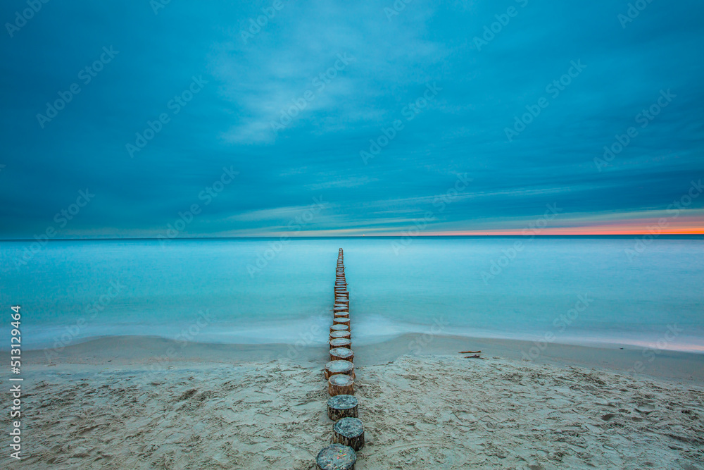 Amazing sunrise over the sea in Chalupy. seascape with breakwater