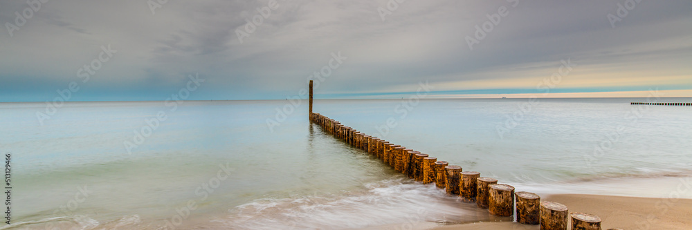 Amazing sunrise over the sea in Chalupy. seascape with breakwater