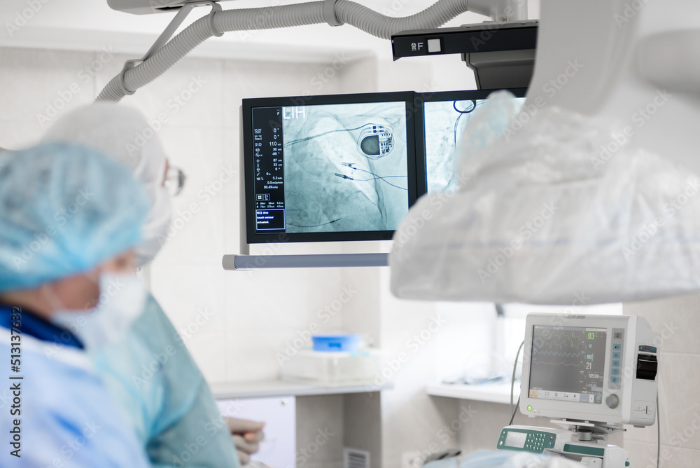 Ταπετσαρία a cardiac surgeon in the operating room, observes on x-ray monitors, a pacemaker installed in a patient