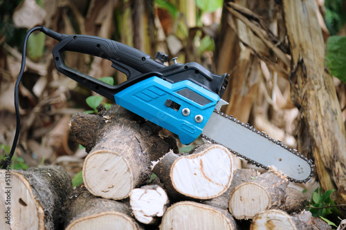 Close up of electric chainsaw laid on lumbers