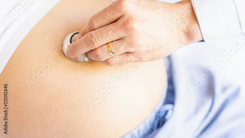 Pregnant woman doctor hospital. Medical clinic for pregnancy consultant. Doctor examining pregnancy woman belly holding stethoscope. Therapy, healthcare, motherhood concept.