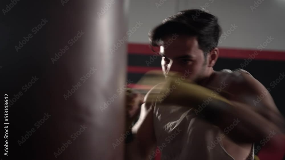Man boxer exercising punches with boxing bag in gym, Boxer hitting a huge punching bag at a boxing studio Man boxer exercising punches with boxing bag in gym, Boxer hitting a huge punching bag at a boxing studio