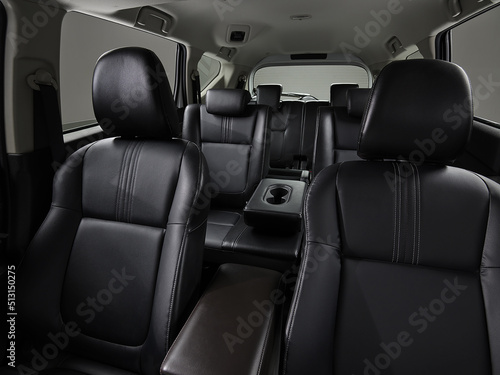 The black seats in modern cars parked outdoors in the garden show both the front and rear seats.