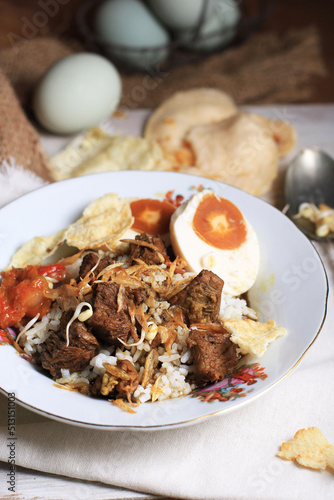 Rawon or Nasi Rawon (Rawon Rice) is a strong rich tasting traditional Indonesian beef black soup served with sprouts, kluwek seasoning. From east java photo