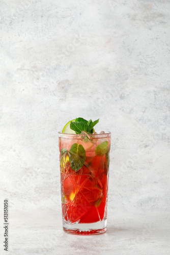 Cocktail with lime and fruit and mint on textured background