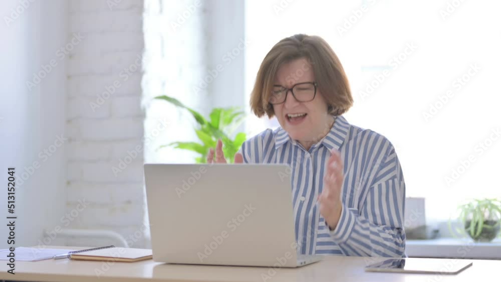 Angry Senior Woman Screaming while Working on Laptop Angry Senior Woman Screaming while Working on Laptop