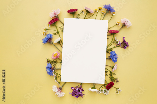 Wishing or invitation mockup stationery card. Birthday, wedding, Mothers day creative card mock up wildflowers flat lay. Place for text. Top view