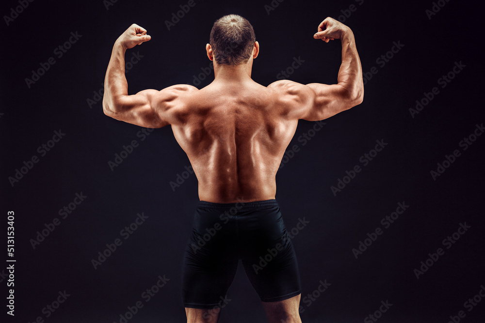 Sportsman of the year. Sportsman back view on black background. Strong sportsman flexing arm muscles triceps biceps. Sportsman or bodybuilder showing muscular back Sportsman of the year. Sportsman back view on black background. Strong sportsman flexing arm muscles triceps biceps. Sportsman or bodybuilder showing muscular back