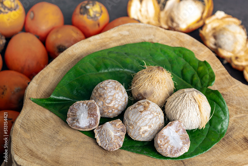 Betel nut or areca nut with betel leaf isolated on wooden background. photo