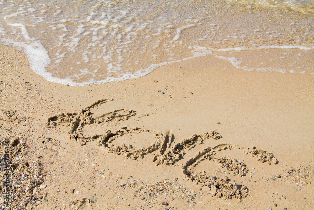 Inscription love sur sable fin et vague. Inscription love sur sable fin et vague.
