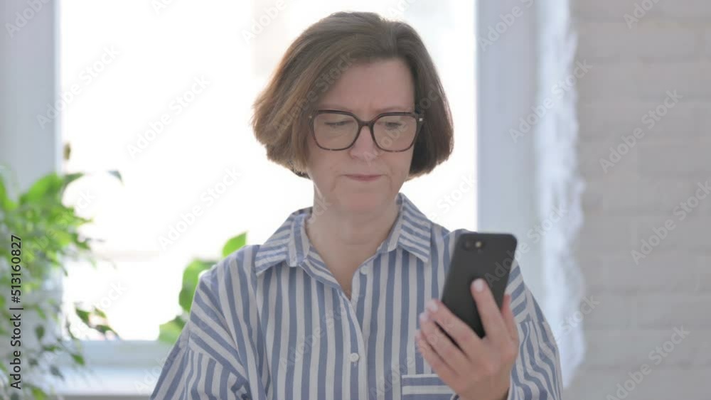 Senior Woman Reacting to Loss on Smartphone Senior Woman Reacting to Loss on Smartphone