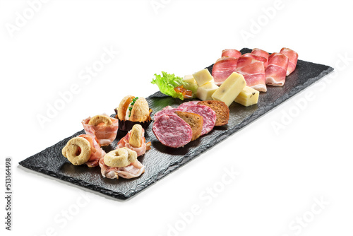 Black stone rectangular tray with snacks speck bacon salami taralli salted macaron cheese with jam photo