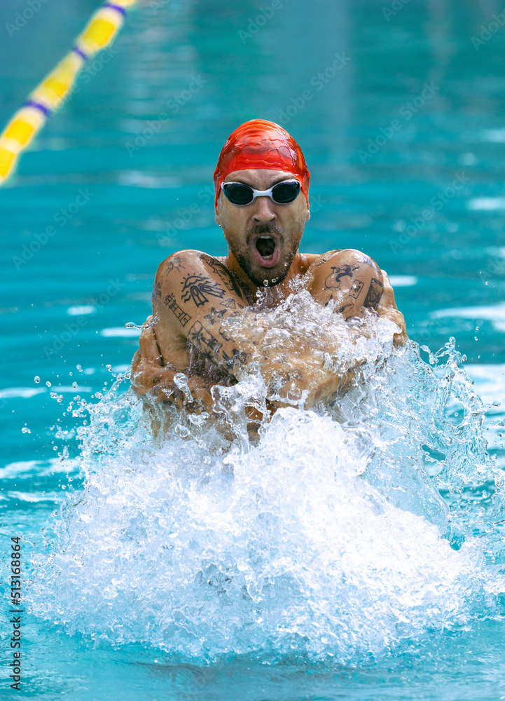 One muscular man, professional swimmer in goggles training at public swimming-pool, outdoors. Sport, power, energy, style, hobby concept.