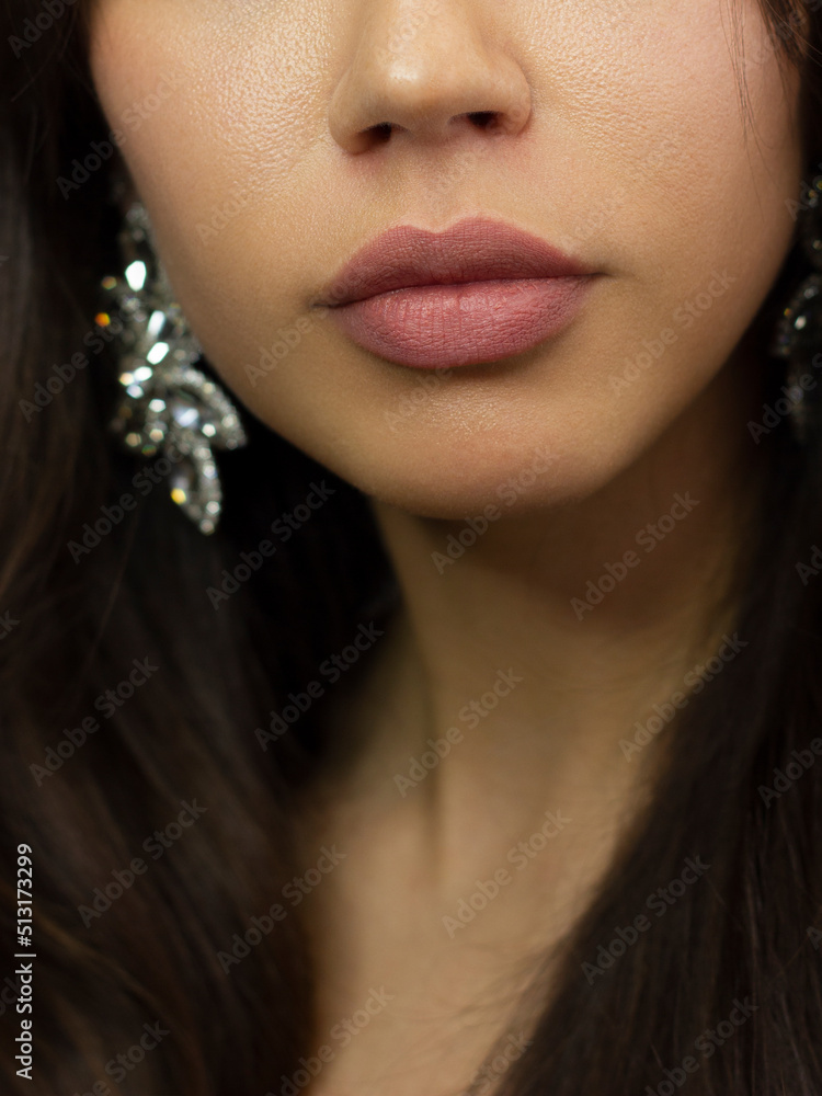 Cosmetics, makeup and trends. Bright lip gloss and lipstick on lips. Closeup of beautiful female mouth with natural lip makeup. Beautiful part of female face. Perfect clean skin