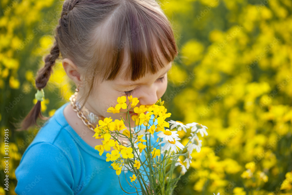 Smiling Little kid girl holding bouquet of fields yellow flowers and chamomiles enjoying summer day. Child giving flowers Smiling Little kid girl holding bouquet of fields yellow flowers and chamomiles enjoying summer day. Child giving flowers