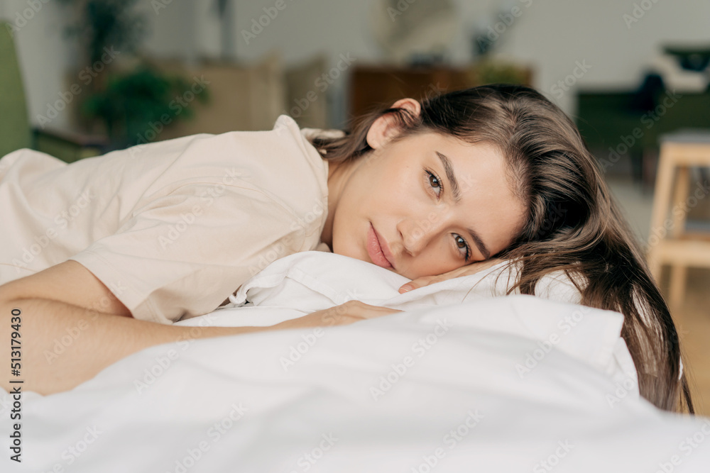 Obraz premium Portrait of a serene resting calm woman lying on a pillow.