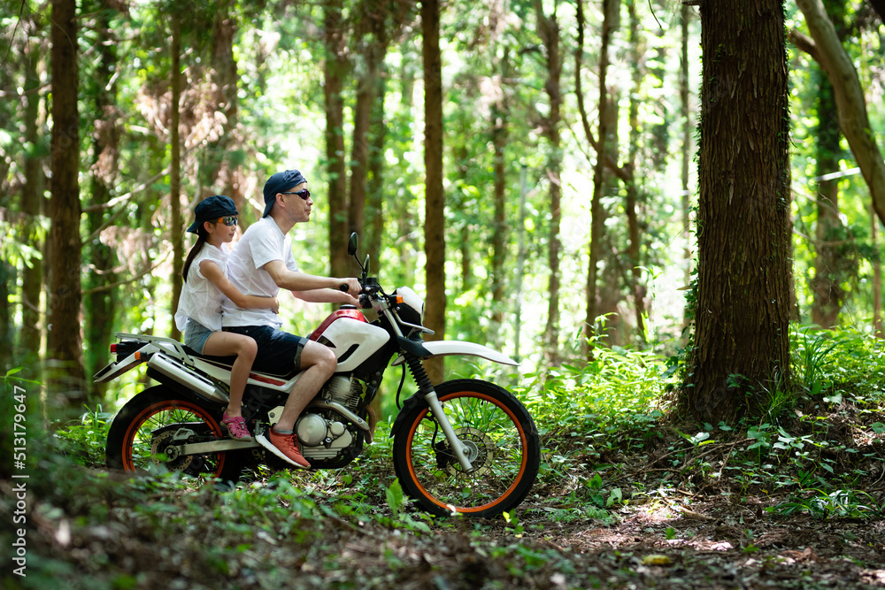 Obraz premium オフロードバイクで山道を走る親子