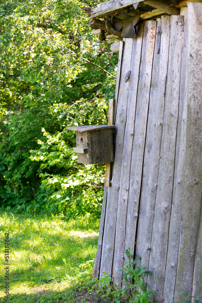 wooden barn with a wooden bird cage attached to the wall. wooden barn with a wooden bird cage attached to the wall.