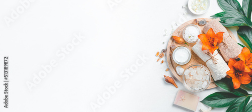 Spa composition with lilies and spa accessories on a light background. Top view, copy space.