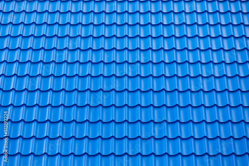Architectural textured background of blue roof metal tile. Roof of a house with modern metal roof tiles