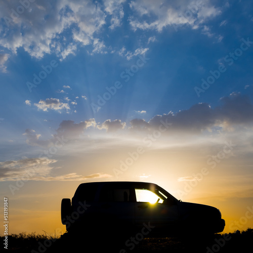 car silhouette on dramatic cloudy sky background at the sunset