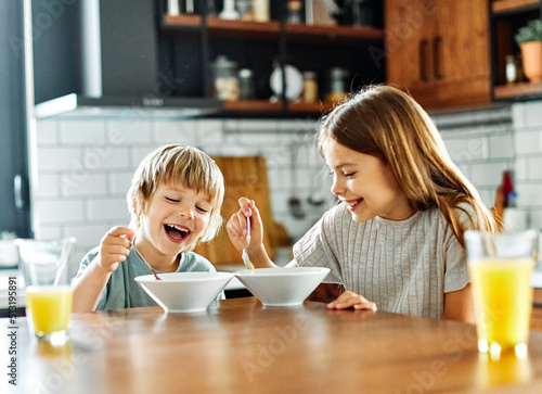 Foto child girl boy eating kid brother sister food breakfast kitchen together morning