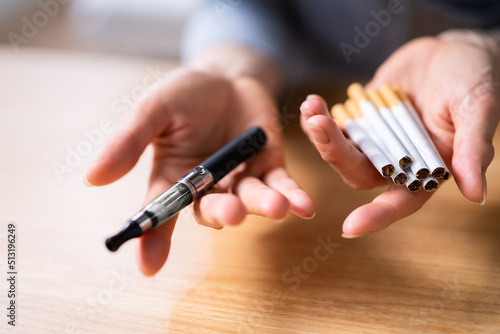 Woman Holding Vape And Tobacco Cigarettes photo