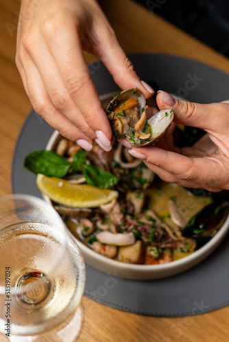 beautiful female hands with red manicure. Young girl holding oysters in her hands in an expensive restaurant. Seafood and Mediterranean cuisine with mussels