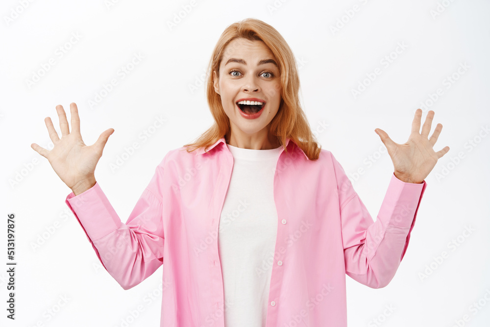 Portrait of excited smiling woman showing smth big with hands, screaming from happiness, standing over white background Portrait of excited smiling woman showing smth big with hands, screaming from happiness, standing over white background