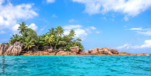 Fototapeta Naklejka Na Ścianę i Meble -  Beautiful island of Seychelles, granite cliffs of the beach with palm trees and azure water. Vacation concept travel holiday banner background. Hawaiian Islands Paradise Beach. Luxury travel.