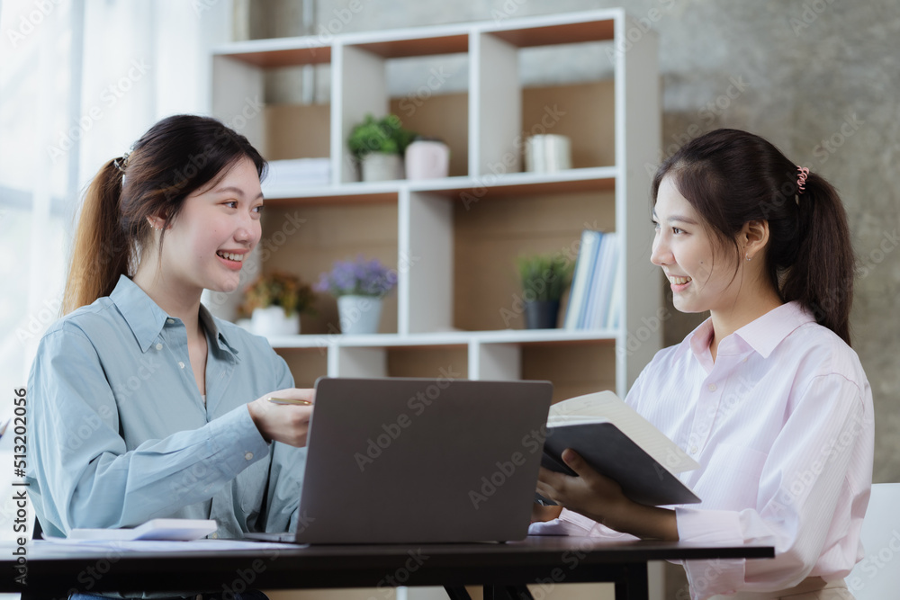 Obraz premium Beautiful Asian woman chatting with colleague in company office, businesswoman operating company administration, staff working as a team in department for planning meeting. Working women concept.
