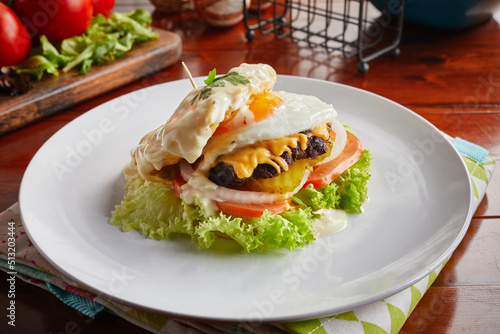 Egg Cream signature Italian Burger served in a dish isolated on wooden background side view