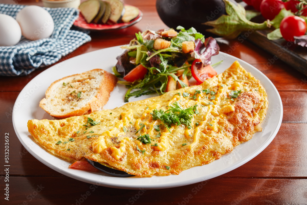 Egg plant cream sauce omelette roll with salad served in a dish isolated on wooden background side view Egg plant cream sauce omelette roll with salad served in a dish isolated on wooden background side view