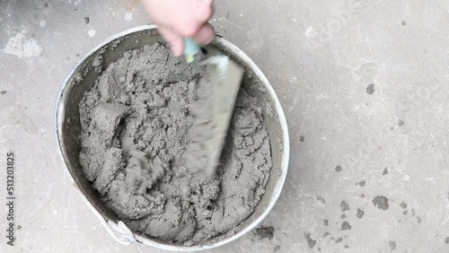 Mixing of concrete mortar.The builder prepares the cement mortar using a construction trowel.Plaster mortar in a bucket.