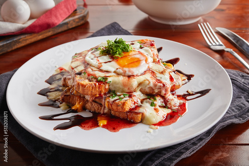 Fusion French Toast with sunny egg served in a dish isolated on wooden background side view