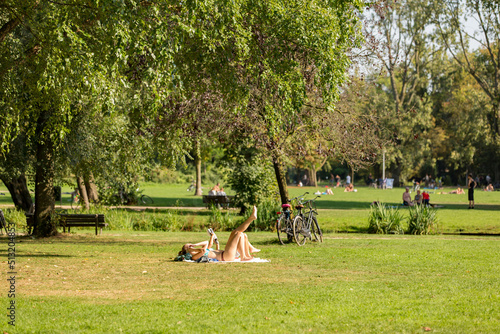 Εκτύπωση καμβά Woman sunbathing on the grass in a sunny Amsterdam Vondelpark in the Netherlands