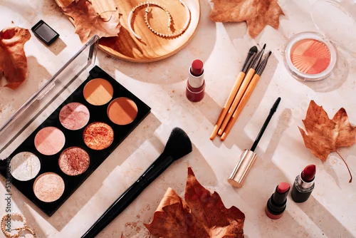 Fototapeta Autumn skincare and autumn makeup concept with beauty products on table