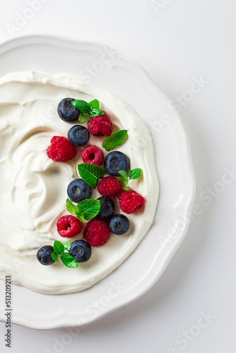 Breakfast, yogurt with fresh berries, raspberries and blueberries, on a white background, selective focus, no people, healthy food,