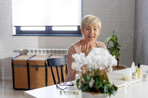 Mature woman taking face treatmant at her home photo