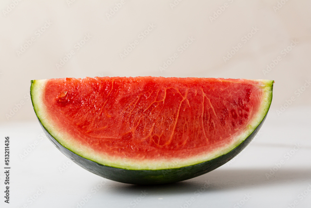 One Slice of red watermelon on light surface summer concept One Slice of red watermelon on light surface summer concept