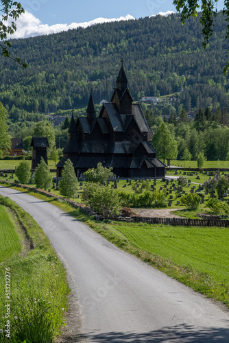 Wallpaper Mural Heddal, Norway - May 26, 2022: Medieval graveyard and Heddal wooden stave church. Heddal Stavkirke, 13th century. Largest stave church in Norway. Sunny spring day.  Selective focus Torontodigital.ca