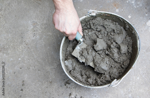 Mixing of concrete mortar.The builder prepares the cement mortar using a construction trowel.Plaster mortar in a bucket